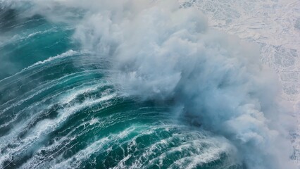 Slow motion aerial shot of powerful wave crashing on rocks. Sea or ocean big stormy surf clear turquoise water with foamy white texture. Aerial drone shot