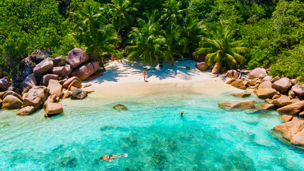 Anse Lazio Praslin Seychelles, a young couple of men and women on a tropical beach during a luxury vacation in Seychelles. Tropical beach Anse Lazio Praslin Seychelles