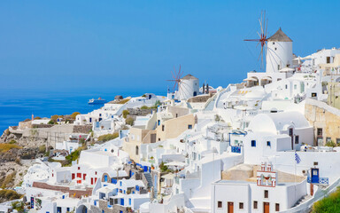 Oia Santorini Greece on a sunny day during summer with whitewashed homes and churches, Greek Island...