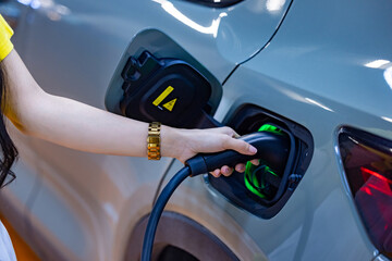 EV charging an electric car.Power supply for electric car charging. Socket for electric car battery charger. EV car charging station. Nature energy, Clean energy, Green eco concept. Plugging in cable.