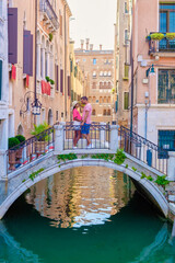 Fototapeta na wymiar a couple of men and women on a city trip in Venice Italy sitting at a bridge in Venice, Italy. Architecture and landmark of Venice. cityscape of Venice Italy during summer
