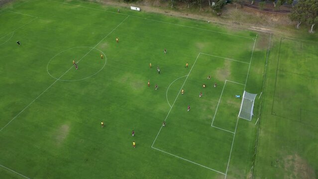 Cinematic drone shot of soccer team scored a spectacular bicycle kick goal during amateur match in Australia - orbiting shot