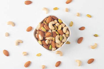 Large assortment of nuts in different bowls on stone table.