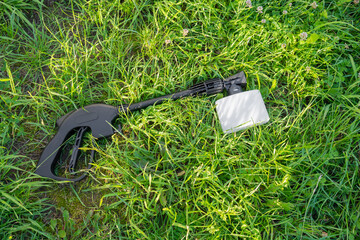 Handle and sprayer of a high-pressure washer with foam generator on green grass