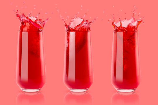 Set of three berry red fresh juices in glass with reflection, bright colorful splashes, flying drops and swirl on pastel pink background. Summer refreshing sweet vegetarian beverage.
