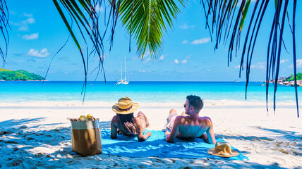 Praslin Seychelles tropical island with withe beaches and palm trees, couple of men and women mid...