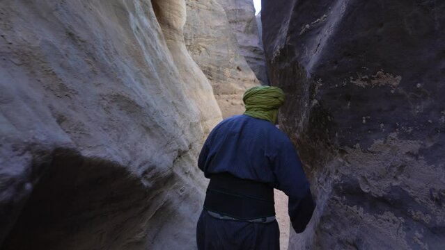 Tuareg in a narrow sandstone path Tassili N'Ajjer Park Tadrart Rouge Algeria