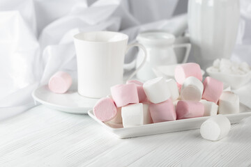 Pink and white marshmallows on a white table.