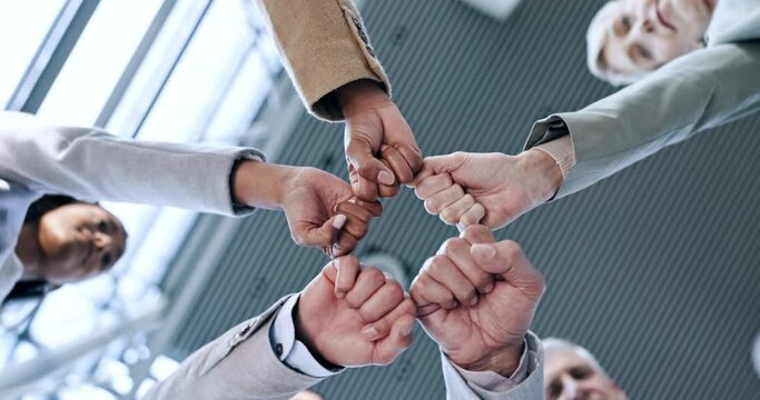 Partnership, teamwork or business people fist bump for motivation for mission, collaboration or support. Hands, low angle or colleagues in meeting huddle with synergy, vision or solidarity together