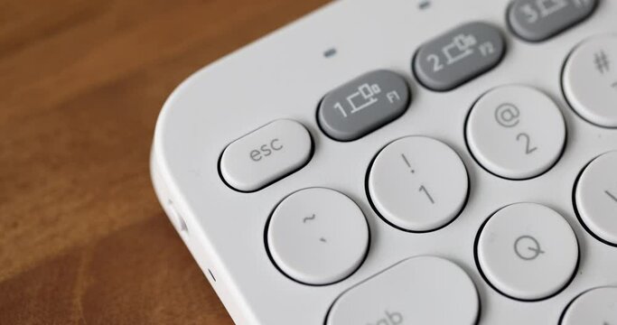 Finger press esc key on white keyboard. Used to return to previous state or exit application or program