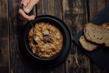 hand holding a spoun of soup