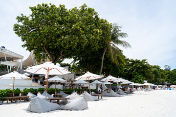 Rows of lounge chairs and sun umbrellas on the white sand beach