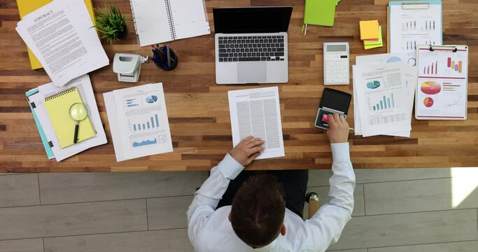 Manager man manually stamps approved contract document top view. Approved seo financial document in office