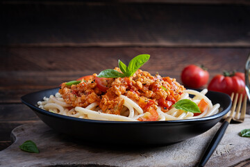 Spaghetti pasta and tomato sauce with chicken mince on a wooden background. Pasta bolognese.