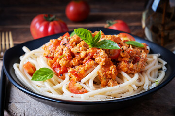 Spaghetti pasta and tomato sauce with chicken mince on a wooden background. Pasta bolognese.