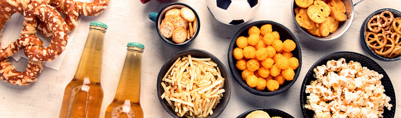 Beer bootles,  snacks and ball on  table.