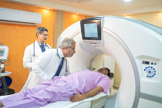 Medical technician starting MRI scan procedure of patient at clinic.