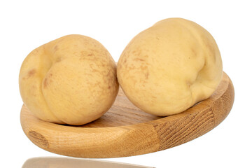 Two organic ripe peaches on a wooden plate, macro, isolated on white background.