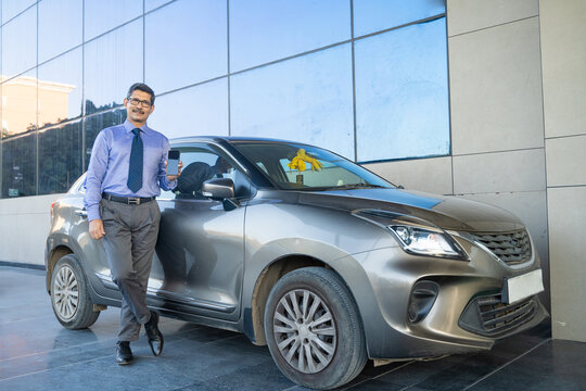 Indian man posing with his car at out of office.