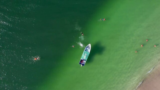 Aerial Drone Flyover Boat With People Swimming In Clear Water Off Conchal Beach, Costa Rica 4K