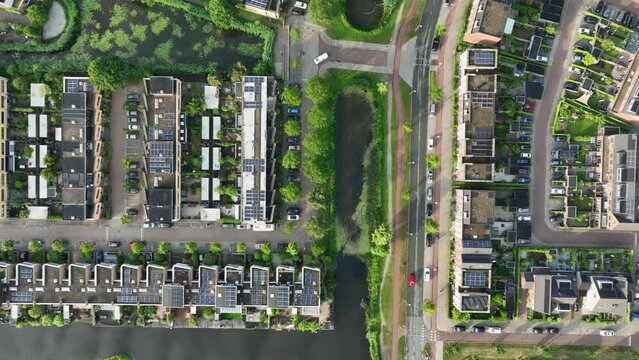 Aerial birdseye view of a city landscape with rows of new houses intermixed with a waterway and streets