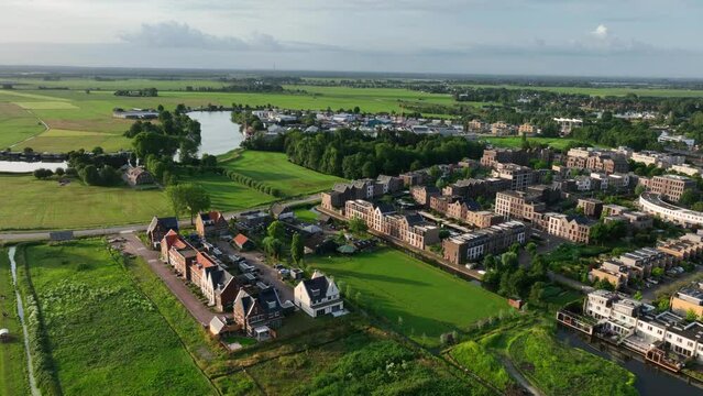 Aerial panning shot of new housing projects on a beautiful summer evening as teh sun sets, in the town of Weesp just outside of Amsterdam Netherlands