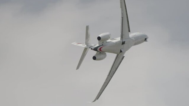 Large white private business Jet during flight under blue sky with clouds