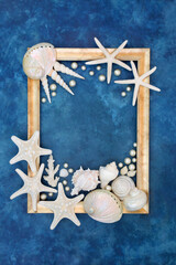 Oyster pearl and seashell abstract with white shells on mottled blue background with gold frame....