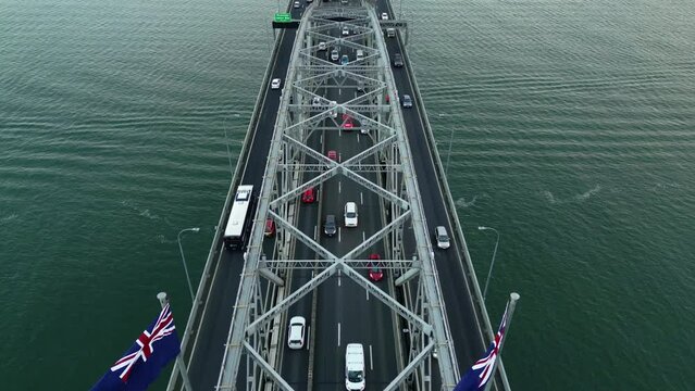 Auckland, New Zealand: Aerial drone footage of the Auckland bay bridge in the Hauraki gulf with heavy traffic in New Zealand largest city. Shot with a backward motion