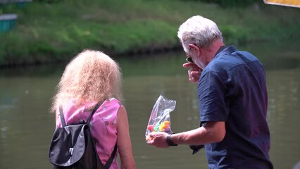 Happy Senior couple enjoy life travel in amusement park feed fish together. activity ageing . elderly retirement lifestyle - Powered by Adobe