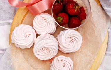 homemade marshmallow zephyr with strawberry taste on wooden boards. strawberries slice , sugar powder top view.food photography