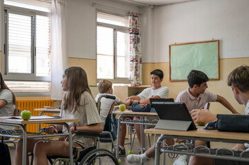 A differently abled preteen in a wheelchair in a high school classroom. Back to school concept with integration