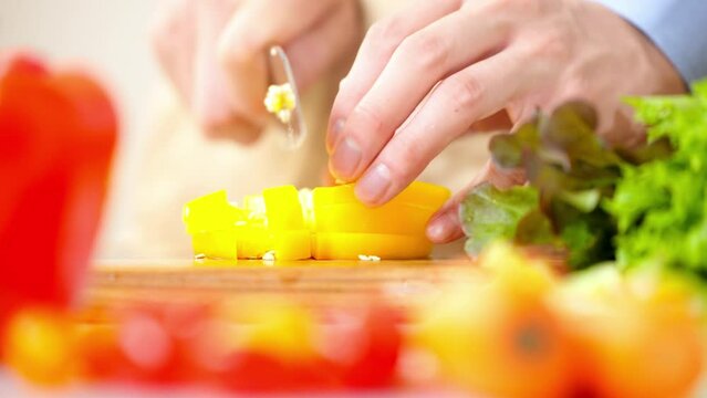 パプリカを切る若い男性　料理イメージ	
