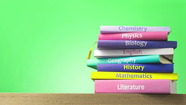 Back to school concept. School textbooks are stacked. Stopmotion animation video, Education and reading concept - group of colorful books on the wooden table. Copy space fot your text