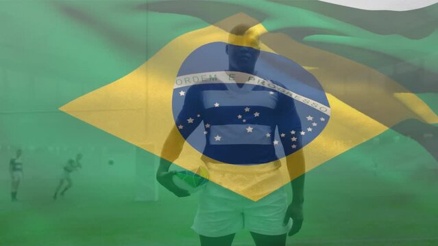 Animation of brazilian flag waving, african american male player with rugby ball standing on ground