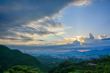 Awe-Inspiring Views of the Sun Shining Through the Clouds and the Dynamic Sky. View of the urban landscape from Dajianshan Mountain, New Taipei City, Taiwan