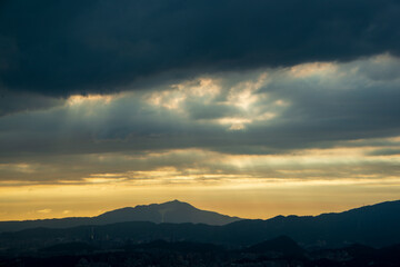 Dynamic Crepuscular Ray and silhouette of Guanyin Mountain. View of the urban landscape from Dajianshan Mountain, New Taipei City.