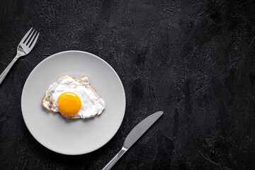 One fried egg on plate, top view. Breakfast background
