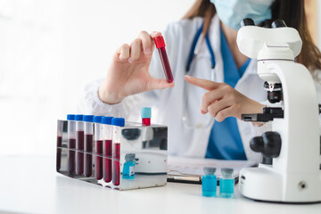 Fototapeta premium Lab work, Doctor holds a test tube takes the test from a test tube in analysis, blood, DNA, test tube stand.