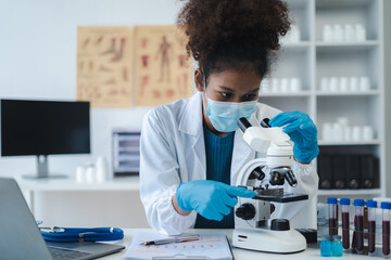 biochemical research scientists working with a microscope for vaccine development in pharmaceutical...