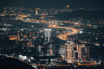 Heavy traffic in the city, time-lapse photography of car lights. View of the urban landscape from Dajianshan Mountain, New Taipei City.