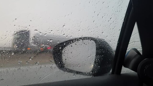 Driving a car during heavy rain. Severe weather conditions while traveling. Shot taken during the day, view through the side window.