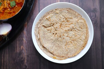 Jowar flour flatbread known as bhakar or jawari bhakri. served with spicy garlic or lasun chutney, green chilli and onion. farmer's food. Maharashtrian village food. copy space