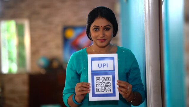 An Indian woman displays QR code, embracing the ease and speed of online payments, a step towards digital empowerment.