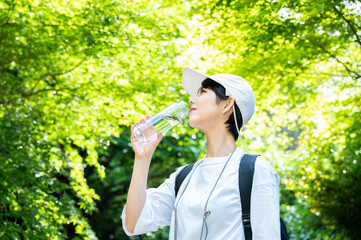 A woman drinking water in the forest