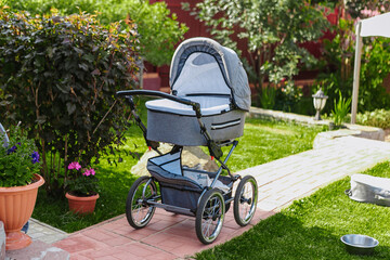 a gray baby stroller is standing on the lawn