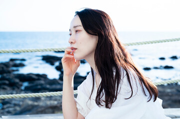 Profile portrait of a beautiful Japanese woman at resort hotel with sea view