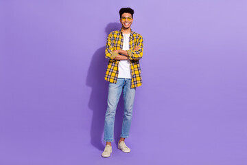 Full length photo of positive nice young man crossed arms posing empty space isolated on violet color background