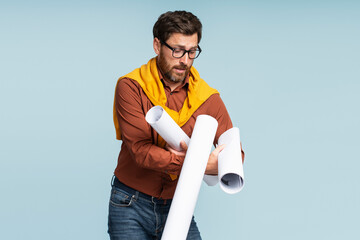 Nerd student wearing eyeglasses catching drawings isolated on blue background. Education concept 