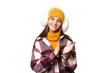 Teenager caucasian girl wearing winter muffs over isolated background applauding after presentation in a conference